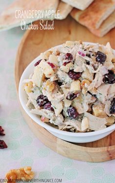 a white bowl filled with chicken salad next to crackers