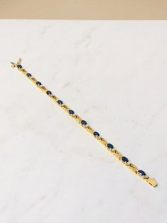 "14kt Yellow Gold Lady's Diamond and Sapphire Bracelet in 7 1/2\" length consisting of 11- 6mm x 4mm Genuine Oval Sapphire Gemstones all faceted with brilliant deep blue color 6.65ct approx. total weight all prong set in basket mountings with 22 full cut round brilliant diamonds .45ct total weight. Each Sapphire has a diamond on each side. The solid open links are hinged for maximum flexibility and comfort. This bracelet has a solid box clasp and secure fig 8 safety clasp. Sapphire is the births Classic 14k Gold Gemstone Tennis Bracelet, Classic 14k Gold Tennis Bracelet With Gemstones, Deep Blue Color, Box Clasp, Sapphire Bracelet, Sapphire Gemstone, Brilliant Diamond, Mens Wedding Bands, Gold Hoop