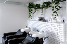 a row of black chairs sitting next to each other in front of a white tiled wall