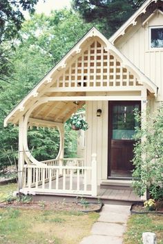 a small white house with a porch in the front yard