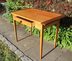 a wooden table sitting on top of a sidewalk