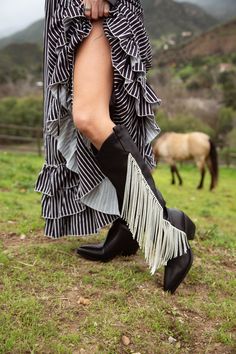 **FINAL SALE - NO EXCHANGES OR RETURNS** Make a statement with JOYDISTRICT Western boot. Cut from black faux leather with crystal cord fringe accents on the sides, these knee high boots bring a touch of luxury to a classic western style. With modern flair on a cowboy boot, these gorgeous shoes are a must-have for a chic western look Western Boots With Rhinestone Fringe For Fall, Western Rhinestone Fringe Boots For Fall, Western Style Fringe Boots For Spring, Western Party Boots With Fringe, Spring Boots With Rhinestone Fringe, Fringe Fitted Boots For Fall, Fitted Fringe Boots For Fall, Fall Fringe Fitted Boots, Western Boot Outfit