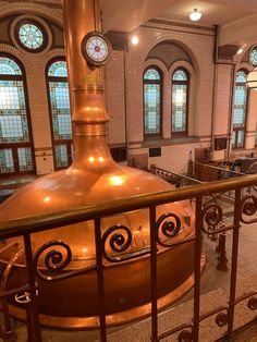 a large copper pot sitting on top of a metal railing