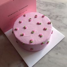 a pink cake with green sprinkles on it next to a card that says romantic standard