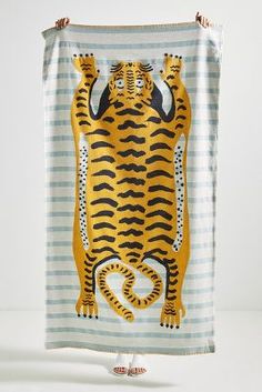 a towel with a tiger on it hanging from a hook in front of a white wall