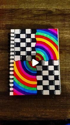 a notebook with an image of a rainbow colored puzzle piece on the cover and a video game controller next to it