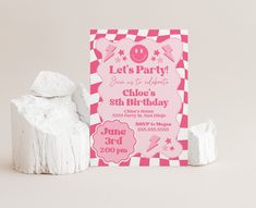 a pink and white checkered birthday party card next to marshmallow candies