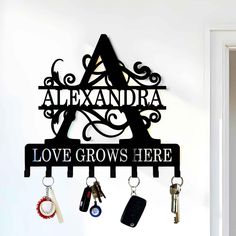 a sign that says love grows here with keys hanging from it