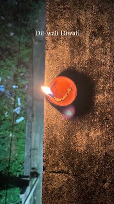 a small orange bowl sitting on top of a dirt ground next to a fire pit