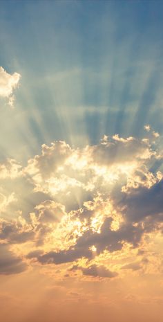 an airplane flying in the sky with sunbeams above it and some clouds behind it