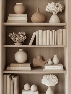 a book shelf filled with books and vases