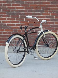 a black and white bicycle parked in front of a brick wall