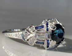 a blue and white diamond ring sitting on top of a table