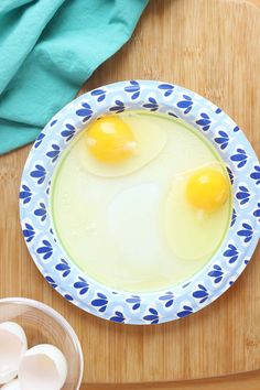 A blue flower paper plate has oil and two cracked large eggs on top. A glass bowl is in front of the plate with the empty eggshells. A turquoise linen is behind the plate and the plate is set on top of a wooden cutting board. Eggs In A Mug Microwave, How To Cook An Egg In The Microwave, Cook Eggs In Microwave, Fried Egg In Microwave, Cook Egg In Microwave, Breakfast Crunchwrap, Fried Egg Recipes, Microwave Mug Recipes, Classic Cobb Salad