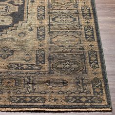 a large rug with an intricate design on the top and bottom, sitting on a wooden floor