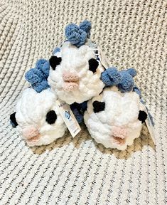 three crocheted stuffed animals sitting on top of a white bed sheet with a price tag