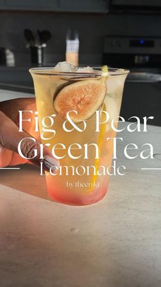 fig and pear green tea lemonade in a glass on a counter with the words fig & pear green tea lemonade