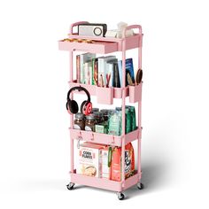 a pink trolley with books, headphones and other items on it's wheels