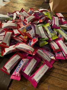 a pile of candy bars sitting on top of a wooden table next to a knife