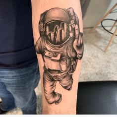 a man's arm with an astronaut tattoo on it