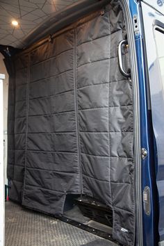 the inside of a van with its door open and curtains pulled back to reveal it's cargo area