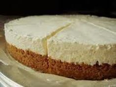 a cake with white frosting sitting on top of a metal pan covered in tin foil