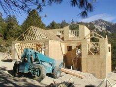 a blue truck parked in front of a house under construction