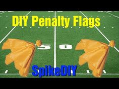 two orange umbrellas sitting on top of a football field with the words diy penalty flags