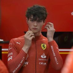 a young man adjusts his red ferrari shirt