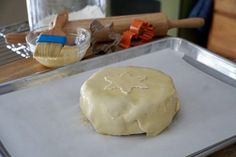 a doughnut sitting on top of a cookie sheet next to a spatula with icing