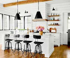 a kitchen with white walls and wooden floors