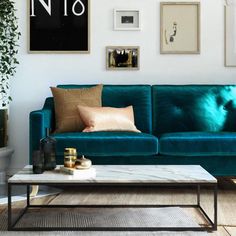 a living room with green couches and pictures on the wall above them, along with a coffee table