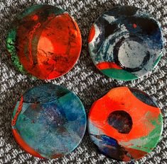 four painted plates sitting on top of a carpet