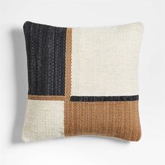 a black, brown and white pillow with two different colors on the front one is made out of woven material