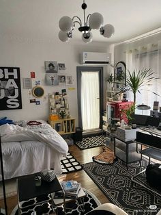 a bedroom with black and white rugs, pictures on the wall and a bed