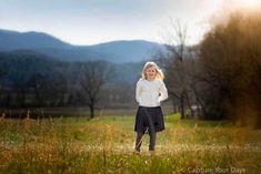 a woman standing in the middle of a field