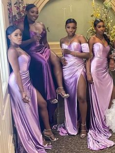 four women in purple dresses posing for the camera