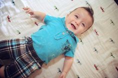 a little boy laying on top of a bed