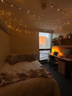 a bedroom with a bed, desk and computer on the wall next to a window