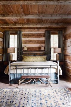 a bed sitting in the middle of a bedroom next to two windows