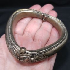 *Description: This is a great embossed design tribal bracelet with a hinge and plunger clasp which makes it very easy to take on and off from the 1940s. The plunger stays attached so you don't have to worry about loosing it. The bracelet has a gold wash, which I tested at 10K gold surface metal. The bracelet under the gold wash is a non-magnetic brass metal; probably mostly hollow. The shape of the bracelet is very unique and is more of a triangular shape with the flat portion on the bottom behi Vintage Hinged Bangle, Vintage Hinged Bracelet Jewelry, Vintage Hinged Bangle Bracelet, Vintage Hinged Bracelet, Vintage Ceremonial Metal Jewelry, Vintage Bronze Cuff Bracelet With Intricate Design, Antique Finish Bangle Jewelry, Vintage Ceremonial Cuff Bracelet With Intricate Design, Antique Jewelry Bangle With Antique Finish