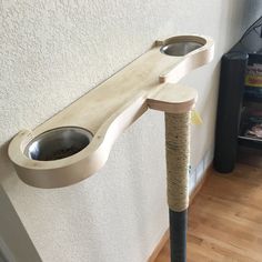 a cat scratching post with two bowls on it