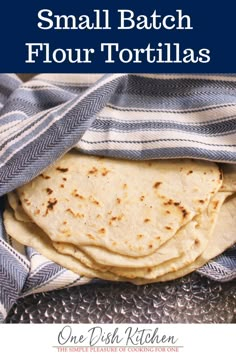 small batch flour tortillas in a blue and white towel with text overlay