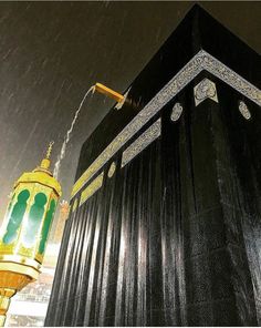 a tall black building with a green and gold lantern