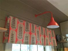 an orange lamp hanging over a window in a kitchen