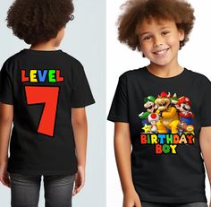 a young boy wearing a birthday shirt with the number seven on it and an image of mario