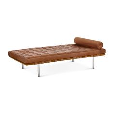 a brown leather couch with metal legs and a roll on the back end, sitting in front of a white background