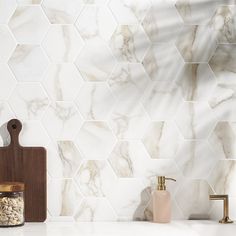 a white marble tile backsplash with wooden cutting board and soap dispenser