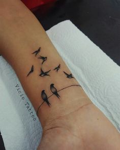 a small wrist tattoo with birds on it