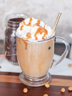 there is a cup of hot chocolate with whipped cream and caramel on the top